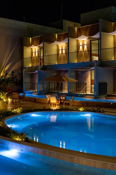 Suítes e piscina iluminadas à noite