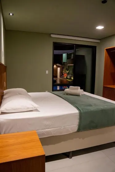 Suíte à noite, com vista para a piscina